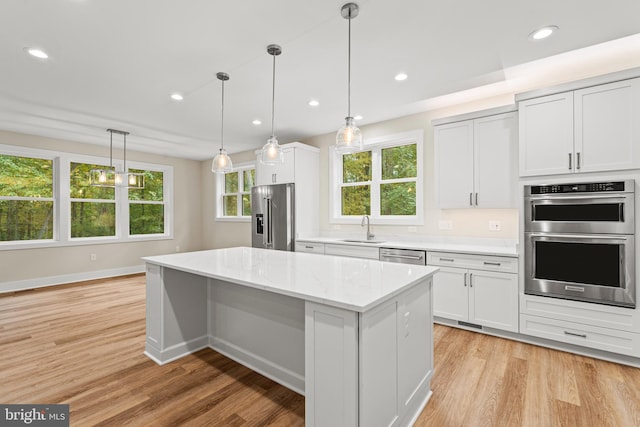 kitchen with white cabinetry, stainless steel appliances, and a wealth of natural light