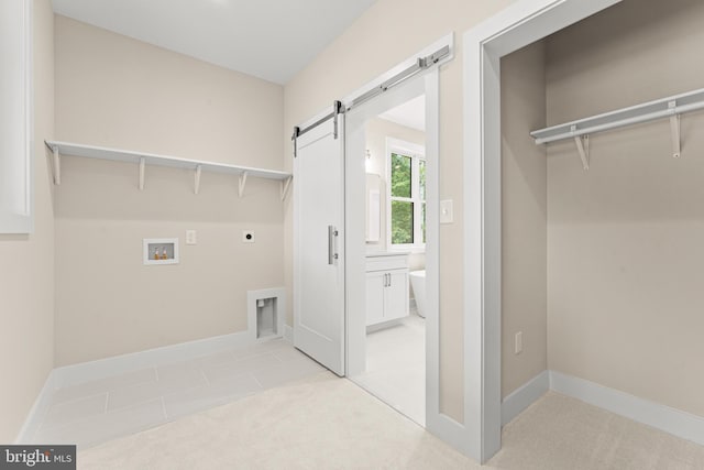 laundry area featuring light carpet, hookup for an electric dryer, a barn door, and hookup for a washing machine