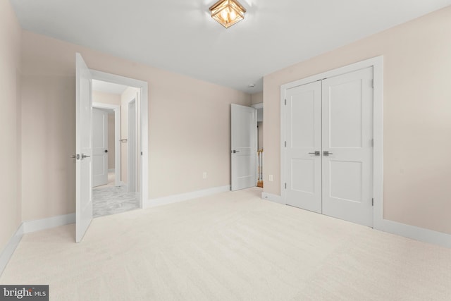 unfurnished bedroom featuring a closet and light colored carpet