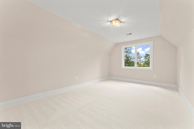 additional living space featuring lofted ceiling and carpet