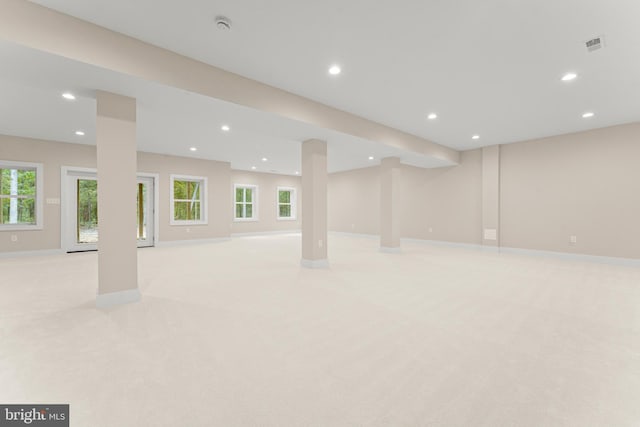 basement with a wealth of natural light and light colored carpet