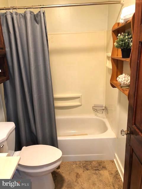 full bathroom with shower / tub combo, vanity, and toilet