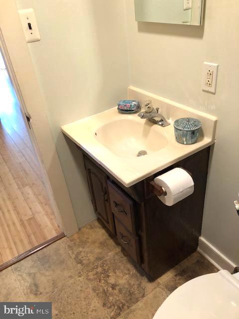 bathroom with hardwood / wood-style floors, vanity, and toilet