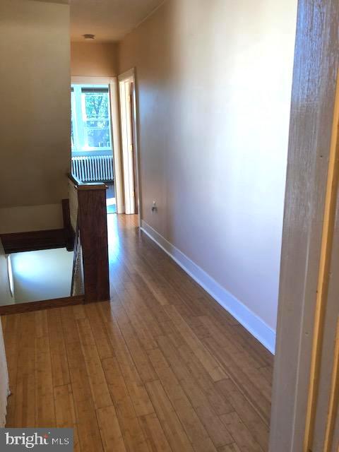 corridor featuring radiator and hardwood / wood-style floors