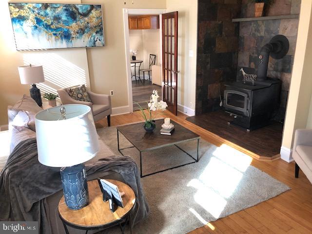 living room featuring a wood stove and hardwood / wood-style flooring