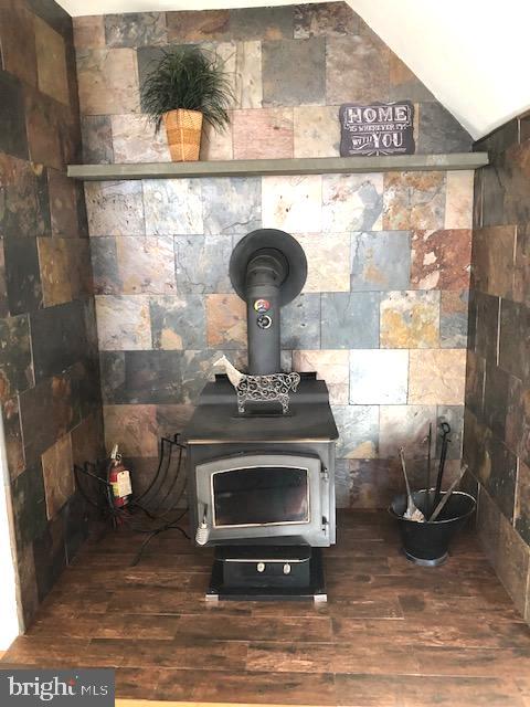 room details with a wood stove and hardwood / wood-style floors