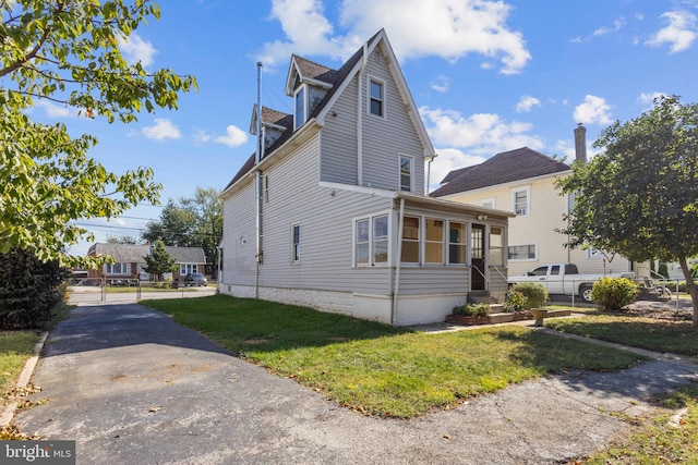 view of side of home with a yard