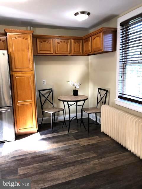 kitchen with radiator, dark hardwood / wood-style floors, and stainless steel fridge