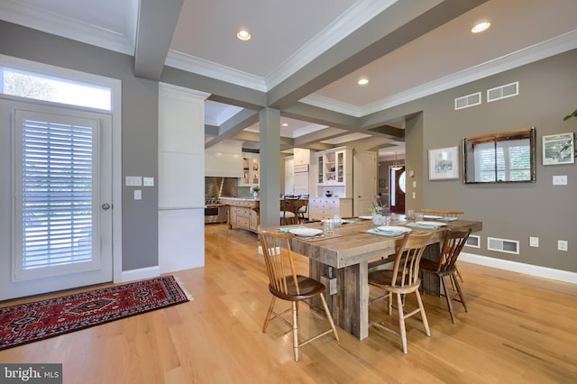 dining area featuring ornamental molding, light wood-style flooring, beamed ceiling, and visible vents