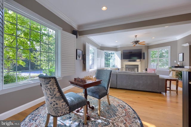 dining room with ornamental molding, recessed lighting, a fireplace, ceiling fan, and light wood-style floors