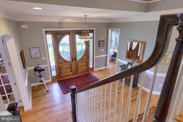 entryway featuring crown molding, light wood-style floors, and baseboards