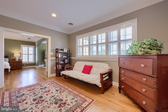 living area with ornamental molding, recessed lighting, light wood-style flooring, arched walkways, and baseboards