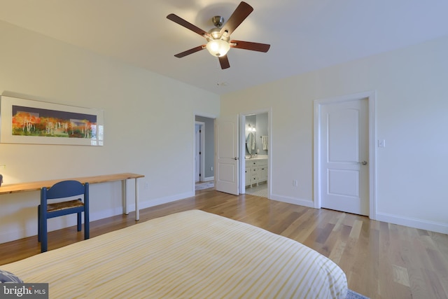 bedroom featuring ensuite bath, baseboards, and wood finished floors