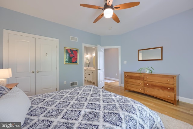 bedroom with a closet, visible vents, and wood finished floors