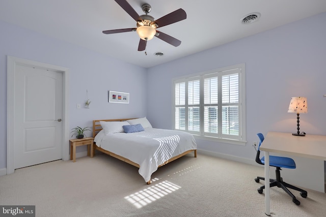 carpeted bedroom with baseboards, a ceiling fan, and visible vents