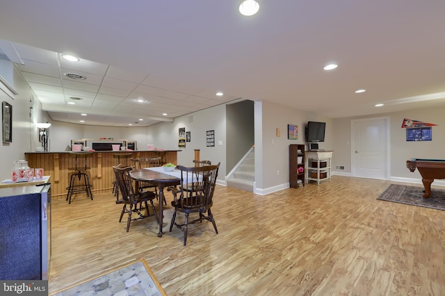dining space featuring bar, visible vents, stairway, baseboards, and light wood-style floors