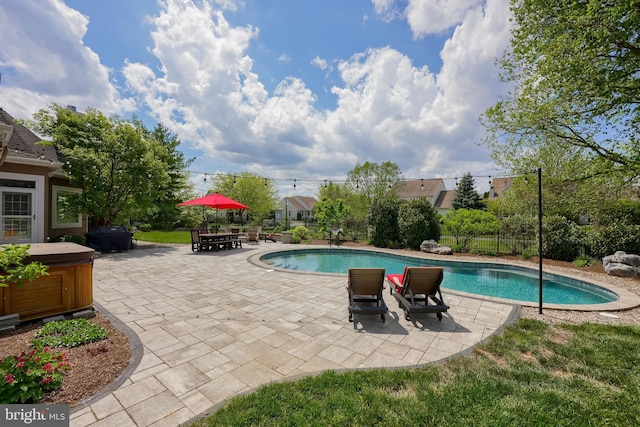 view of swimming pool with a hot tub, fence, a fenced in pool, and a patio area