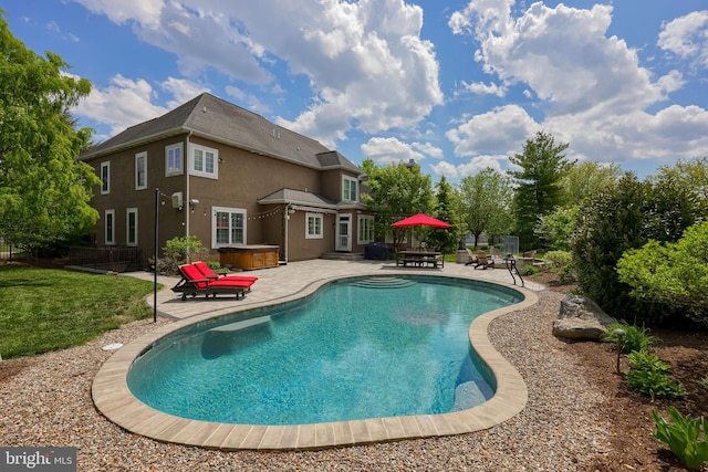 pool with a yard, a patio area, a hot tub, and fence