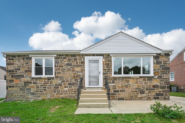 view of front of house with a front yard and central AC unit