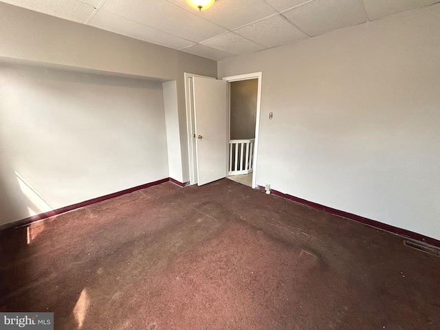 empty room with a paneled ceiling and carpet