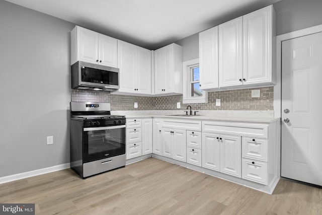 kitchen featuring light hardwood / wood-style floors, white cabinets, stainless steel appliances, and sink