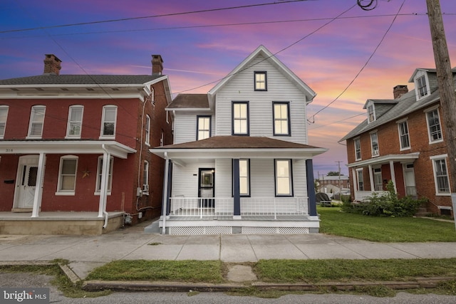 view of front of property with a yard and covered porch