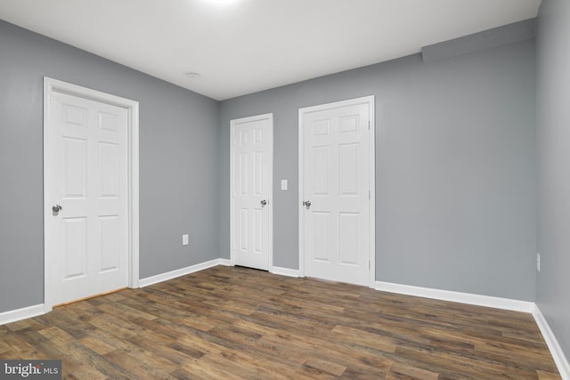 unfurnished bedroom with dark hardwood / wood-style flooring