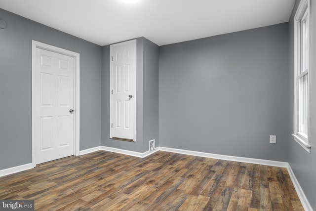 unfurnished room featuring dark wood-type flooring