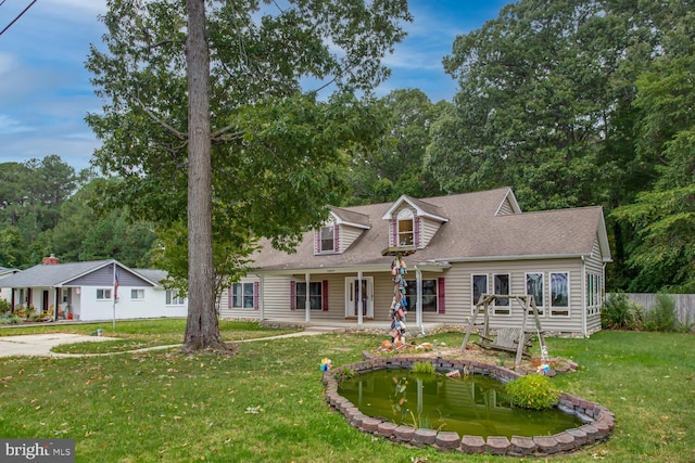 cape cod home featuring a front yard