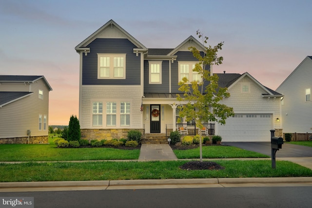 craftsman inspired home with a garage and a yard