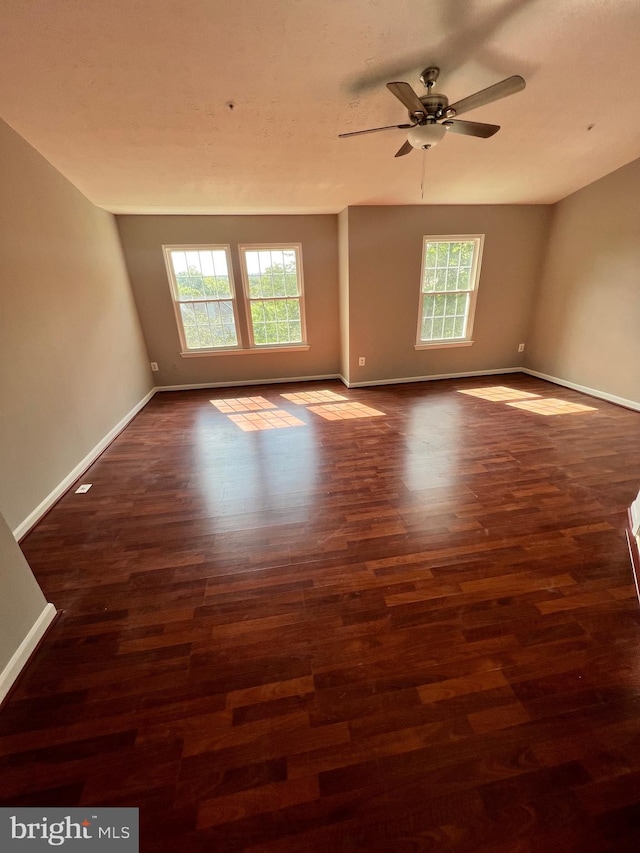 spare room featuring ceiling fan and dark wood-type flooring