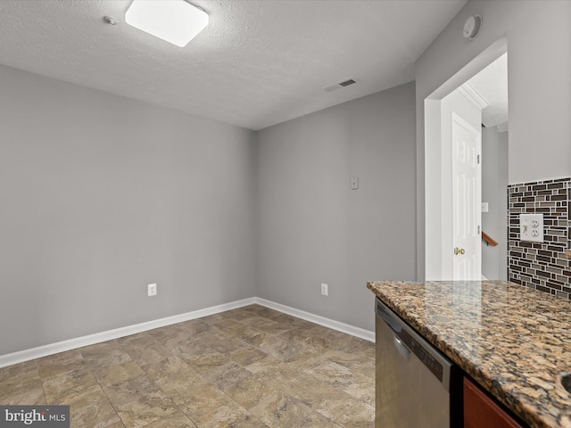 kitchen featuring a textured ceiling, dark stone countertops, stainless steel dishwasher, and backsplash