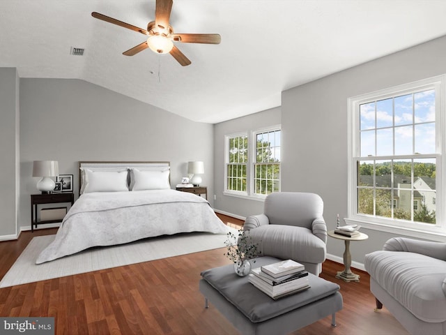 bedroom with hardwood / wood-style floors, multiple windows, ceiling fan, and vaulted ceiling