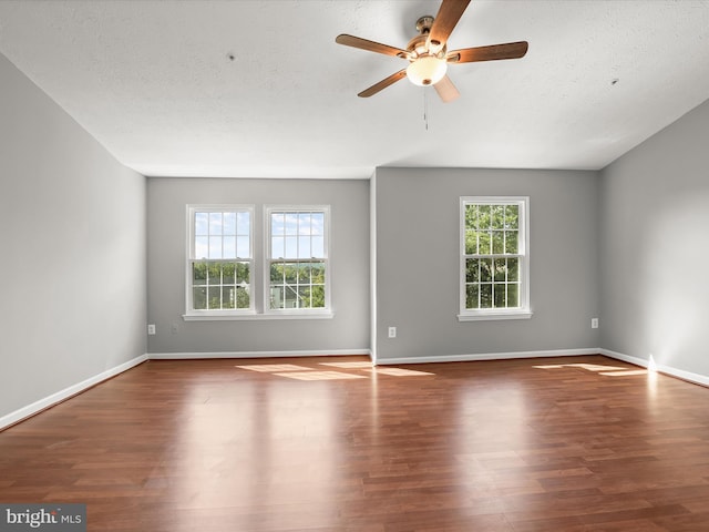 empty room featuring ceiling fan, dark hardwood / wood-style flooring, and a textured ceiling