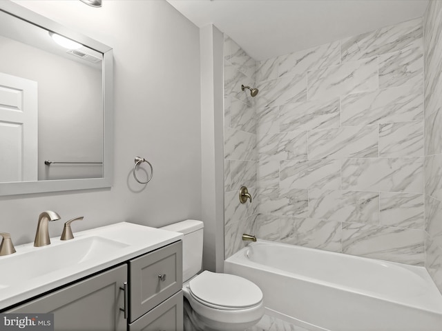 full bathroom with vanity, tiled shower / bath combo, and toilet