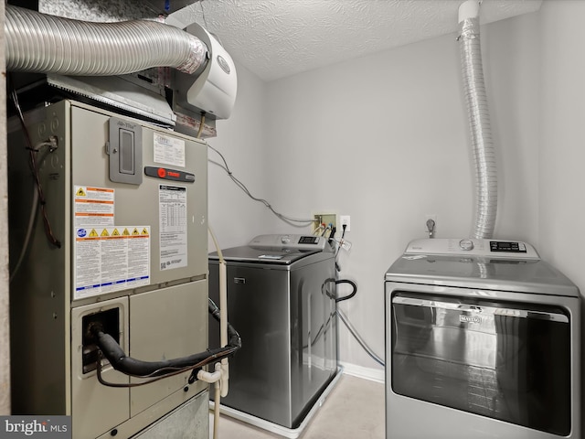 laundry area featuring heating unit, separate washer and dryer, and a textured ceiling