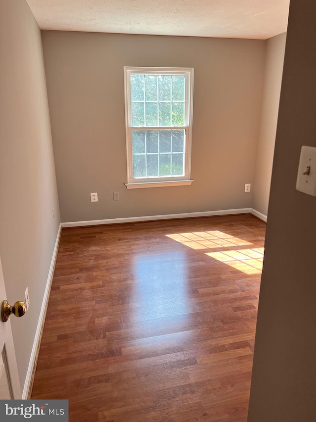 unfurnished room with dark wood-type flooring