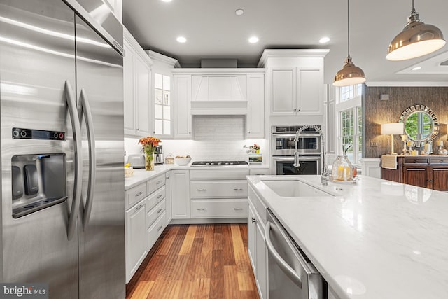 kitchen with white cabinets, stainless steel appliances, hanging light fixtures, and dark hardwood / wood-style floors