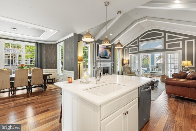 kitchen with white cabinets, sink, an island with sink, and decorative light fixtures