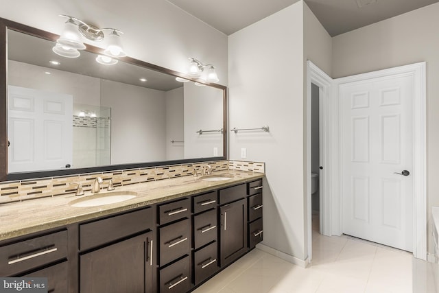 bathroom with toilet, vanity, tasteful backsplash, and tile patterned floors