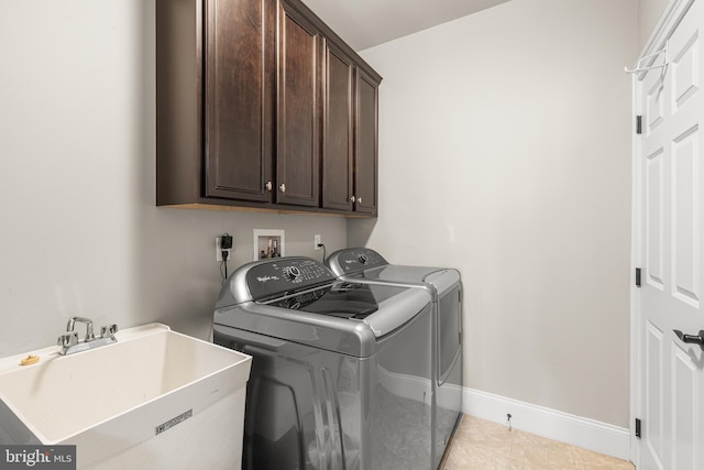 laundry room featuring cabinets, sink, light tile patterned floors, and washer and dryer