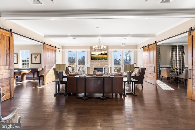 living room featuring a barn door, plenty of natural light, dark hardwood / wood-style floors, and pool table