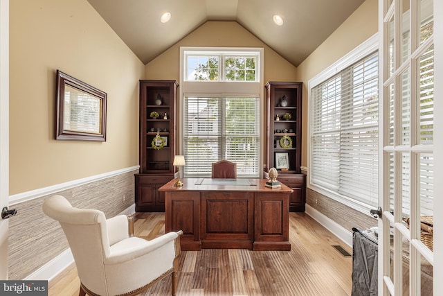 home office with french doors, light hardwood / wood-style floors, and vaulted ceiling