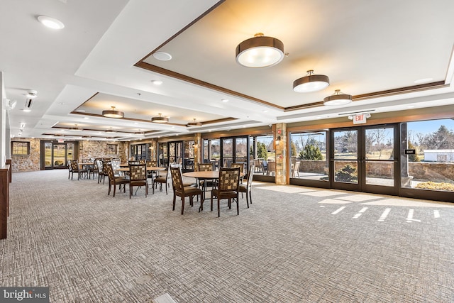 unfurnished dining area featuring a raised ceiling, carpet flooring, and french doors