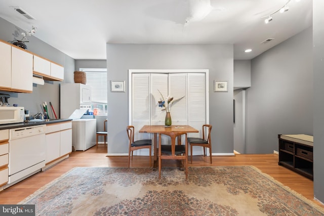 kitchen with white cabinetry, light wood-type flooring, and white appliances