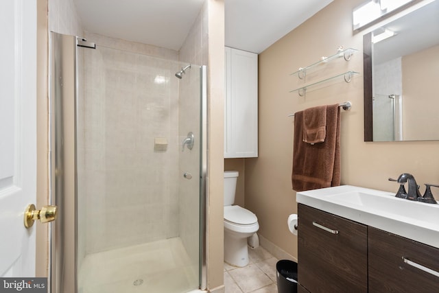 bathroom with an enclosed shower, vanity, toilet, and tile patterned flooring