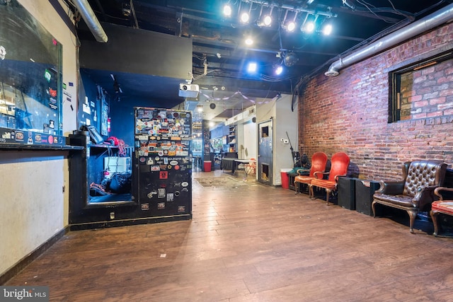 interior space featuring brick wall and hardwood / wood-style flooring