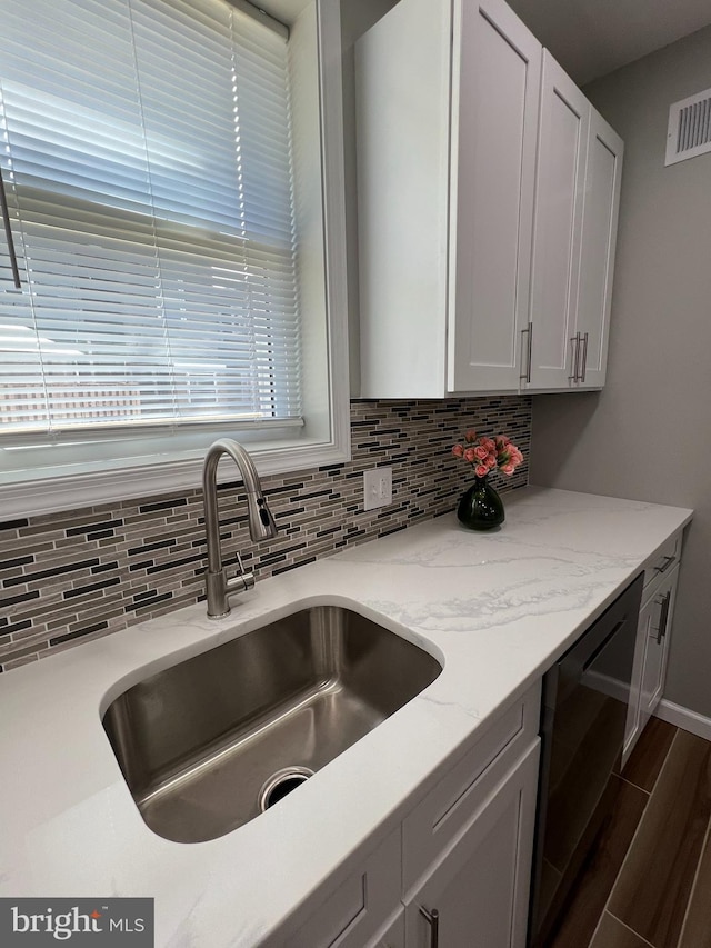 kitchen with backsplash, white cabinets, sink, and plenty of natural light