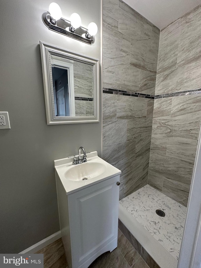 bathroom featuring a tile shower and vanity