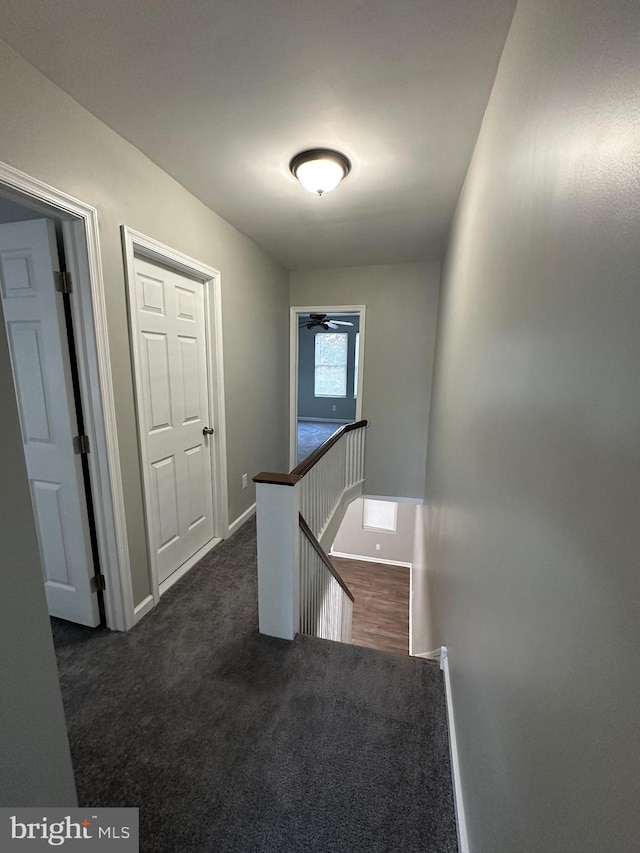 hallway with dark colored carpet